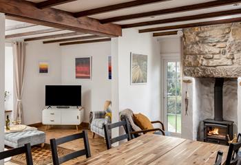 The bright open plan living space at Trewinel Cottage with a door to the enclosed garden. 