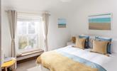 The king size bedroom is decorated with a beach theme featuring lovely artwork. - Thumbnail Image