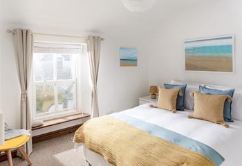 The king size bedroom is decorated with a beach theme featuring lovely artwork.