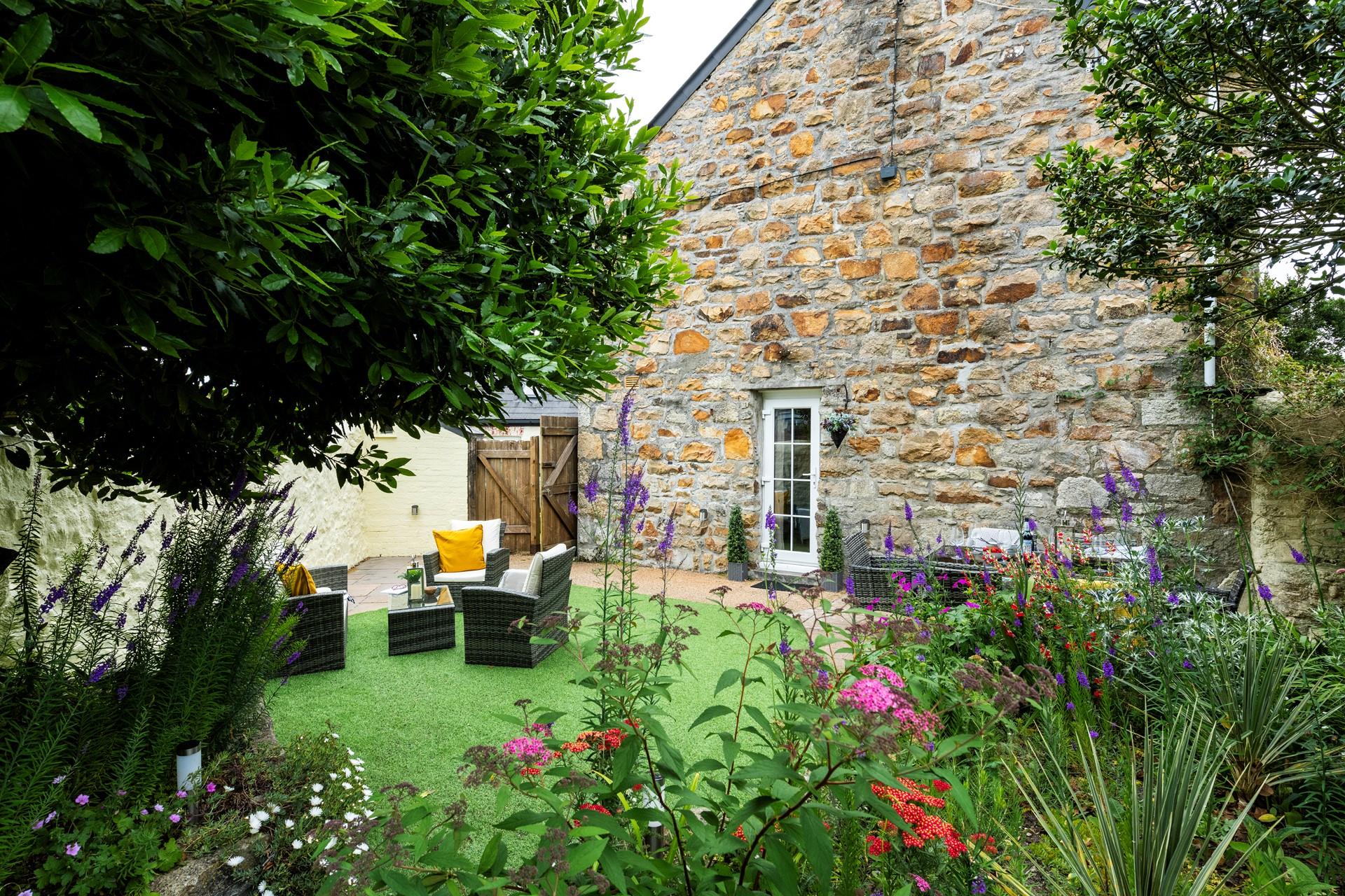 The garden is blooming with flowers in the summer sunshine.