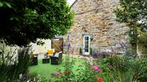 The garden is blooming with flowers in the summer sunshine.