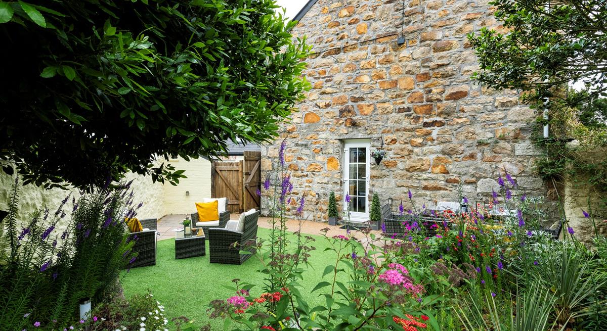 The garden is blooming with flowers in the summer sunshine.