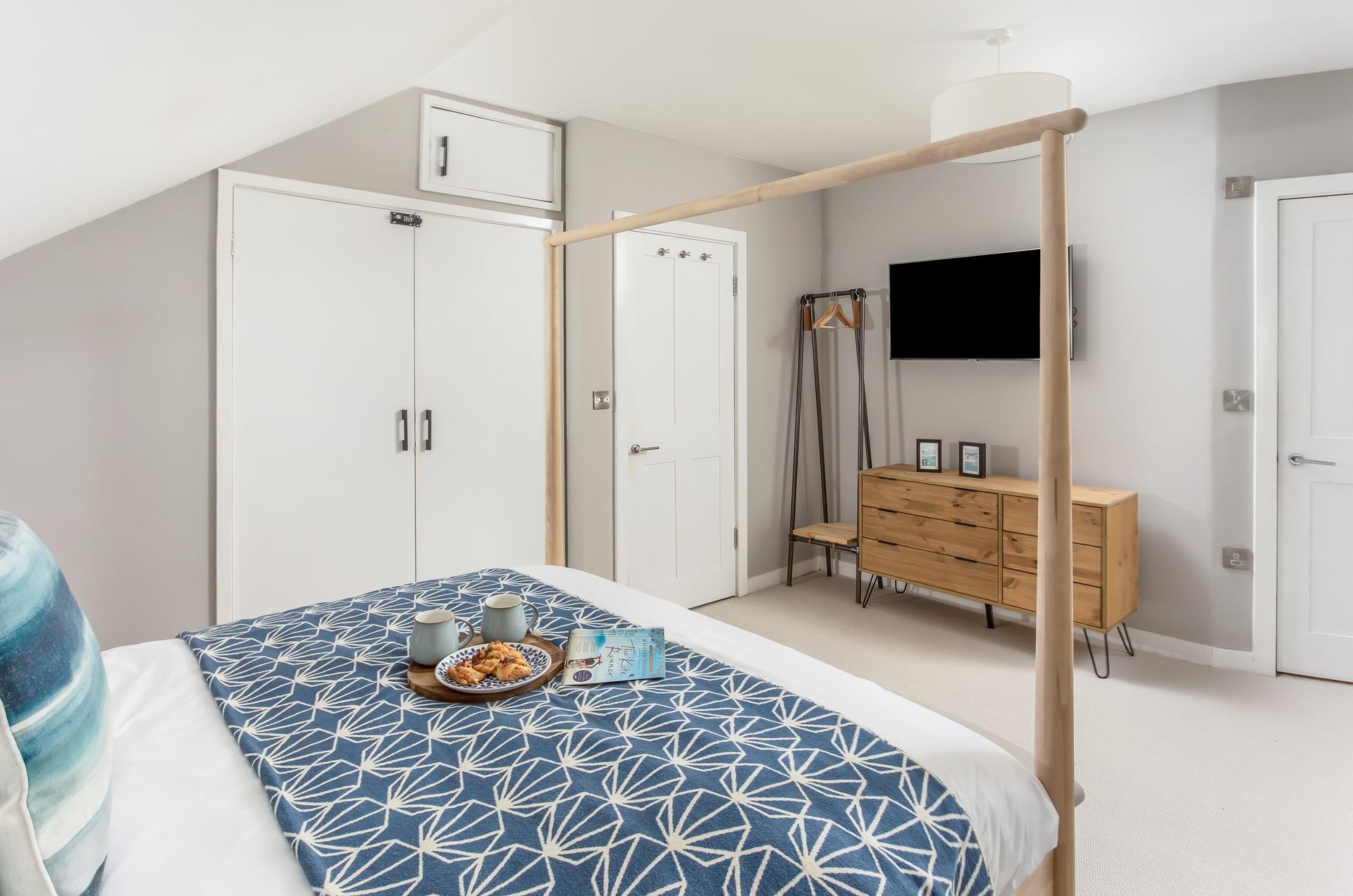 There is ample storage space with a hanging rail and a chest of drawers.