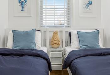 The nautical feel continues in the light and bright twin bedroom.