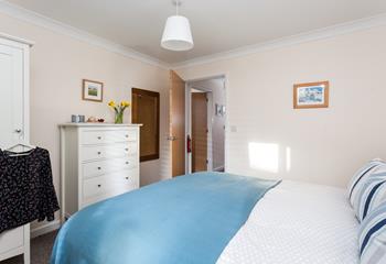The bedroom is decorated with a calming blue colour scheme, that reflects the close proximity to the sea.