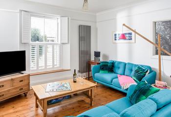 The bright blue sofas add a pop of colour to the stylish open plan living space.
