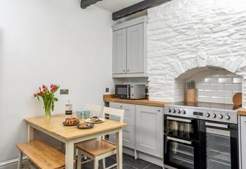The cottage-style kitchen has traditional exposed beams and original stone.