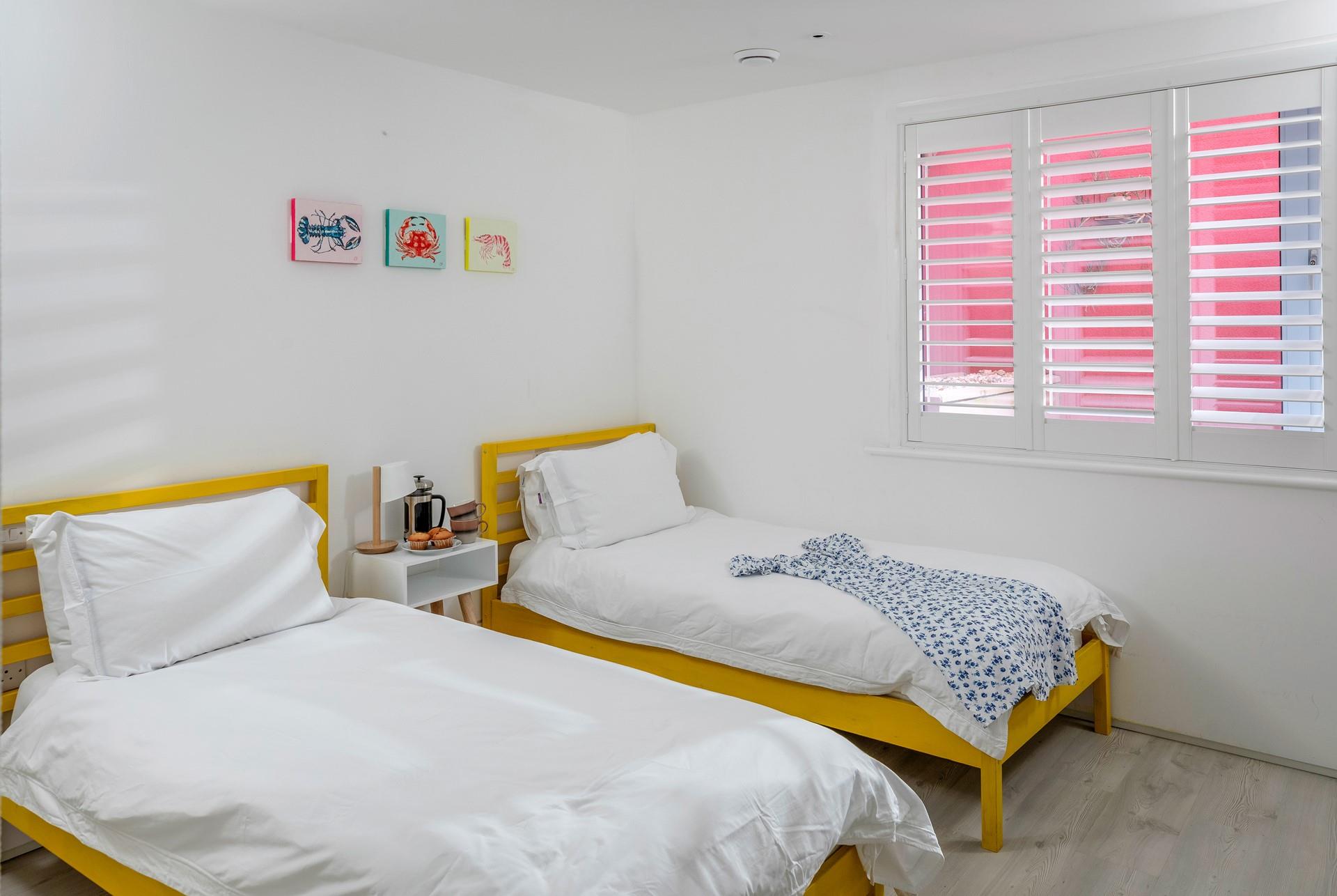 Pops of colour continue in the second twin bedroom.