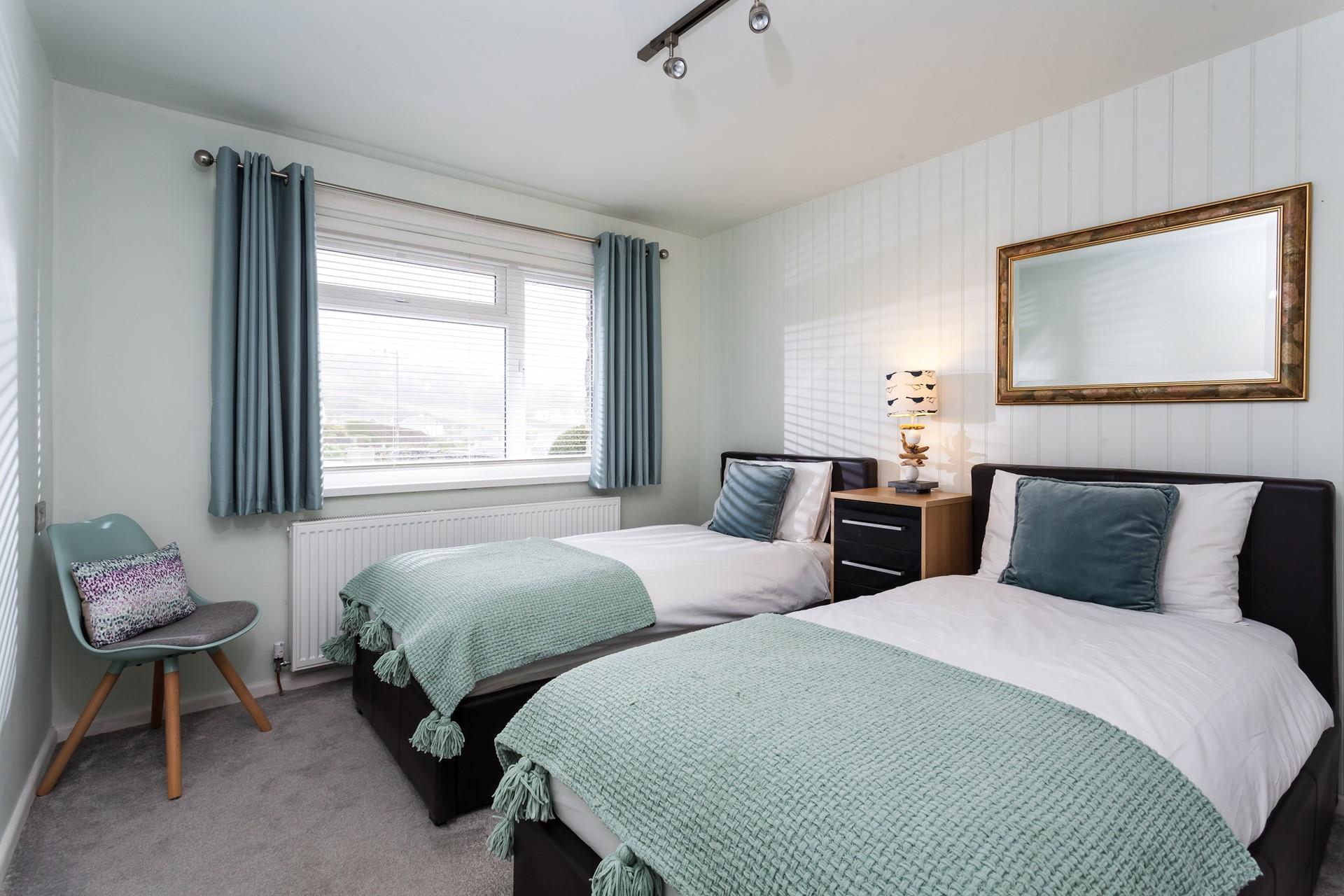 The twin room is decorated with a stylish blue and green colour scheme.