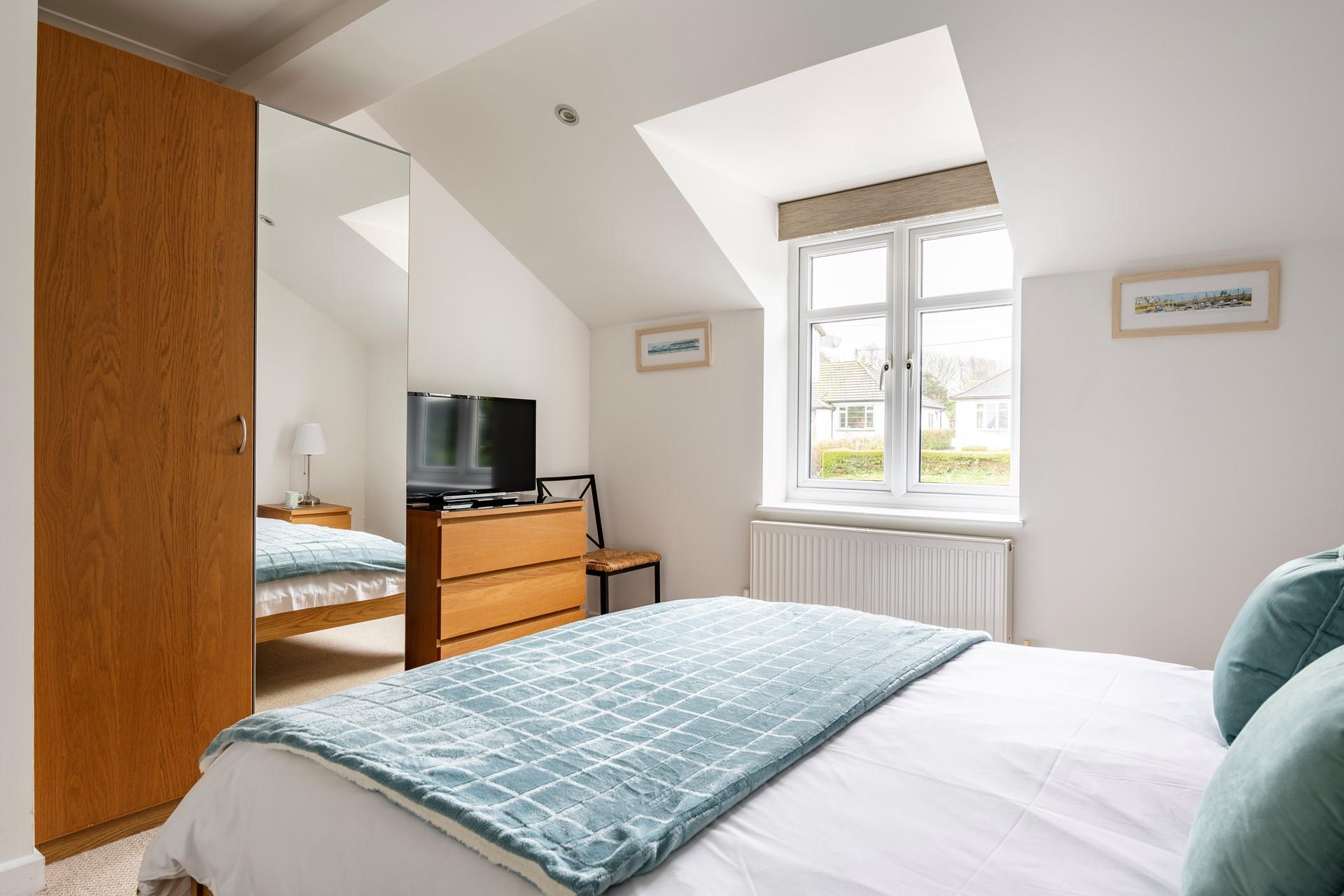 The bedroom has plenty of storage space and a cosy king size bed.