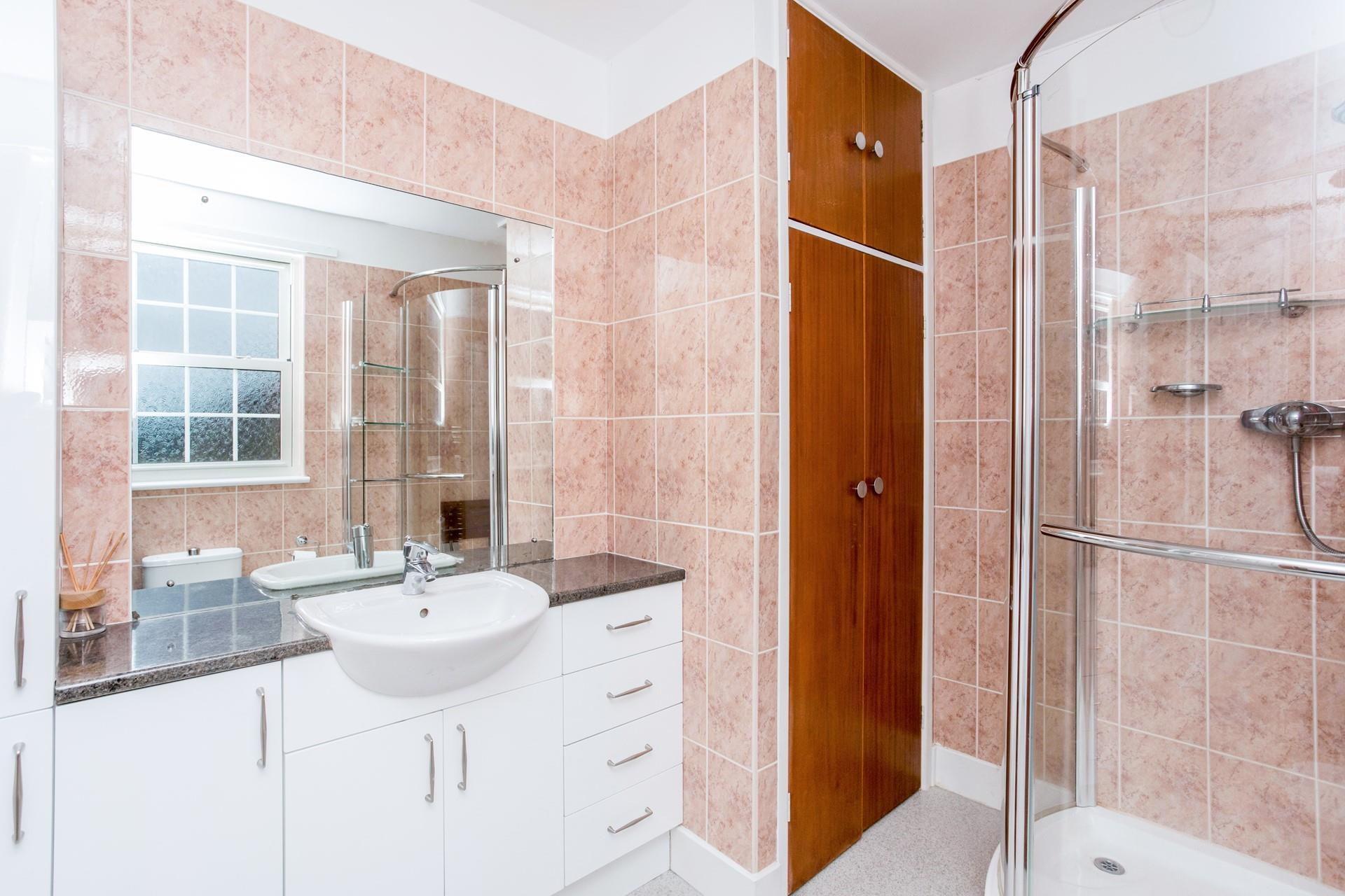 A spacious family bathroom with walk-in shower and deep sink.