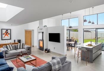 The uber stylish open plan living space features a crackling woodburner for cosy nights in.