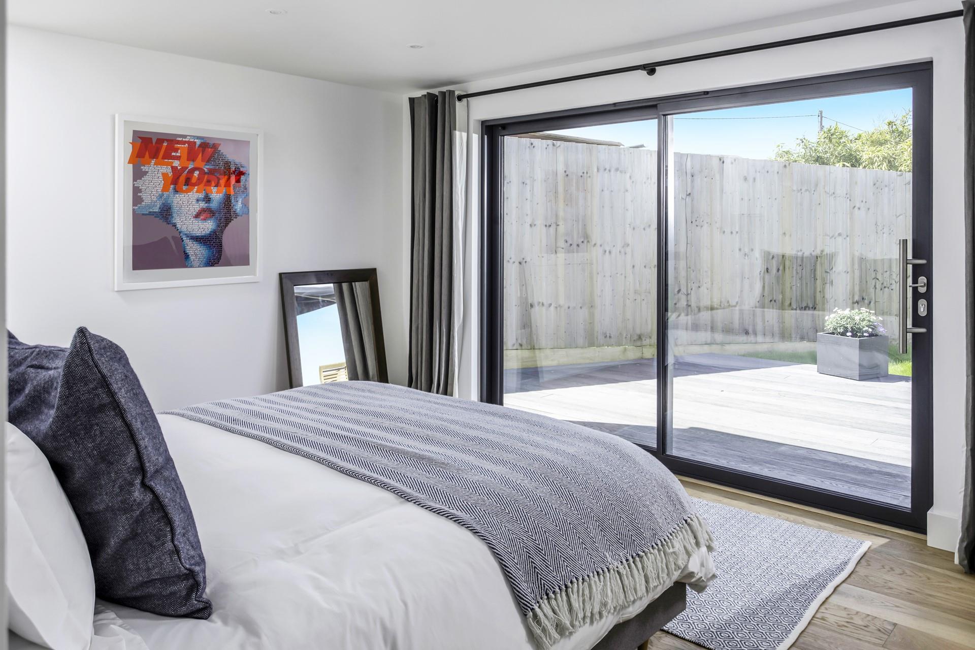 The bedroom is decorated with calming blue tones reflecting the close proximity to the ocean.