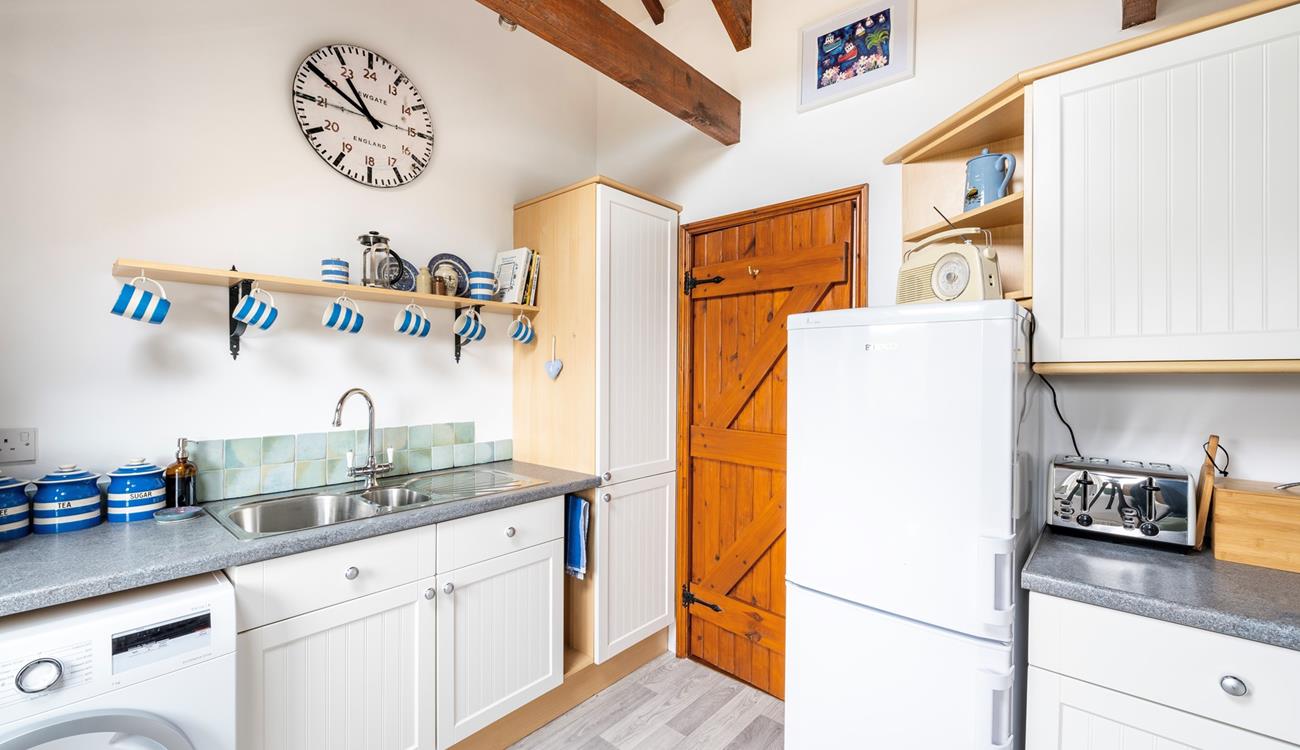The fully equipped kitchen has matching crockery for the perfect afternoon tea.