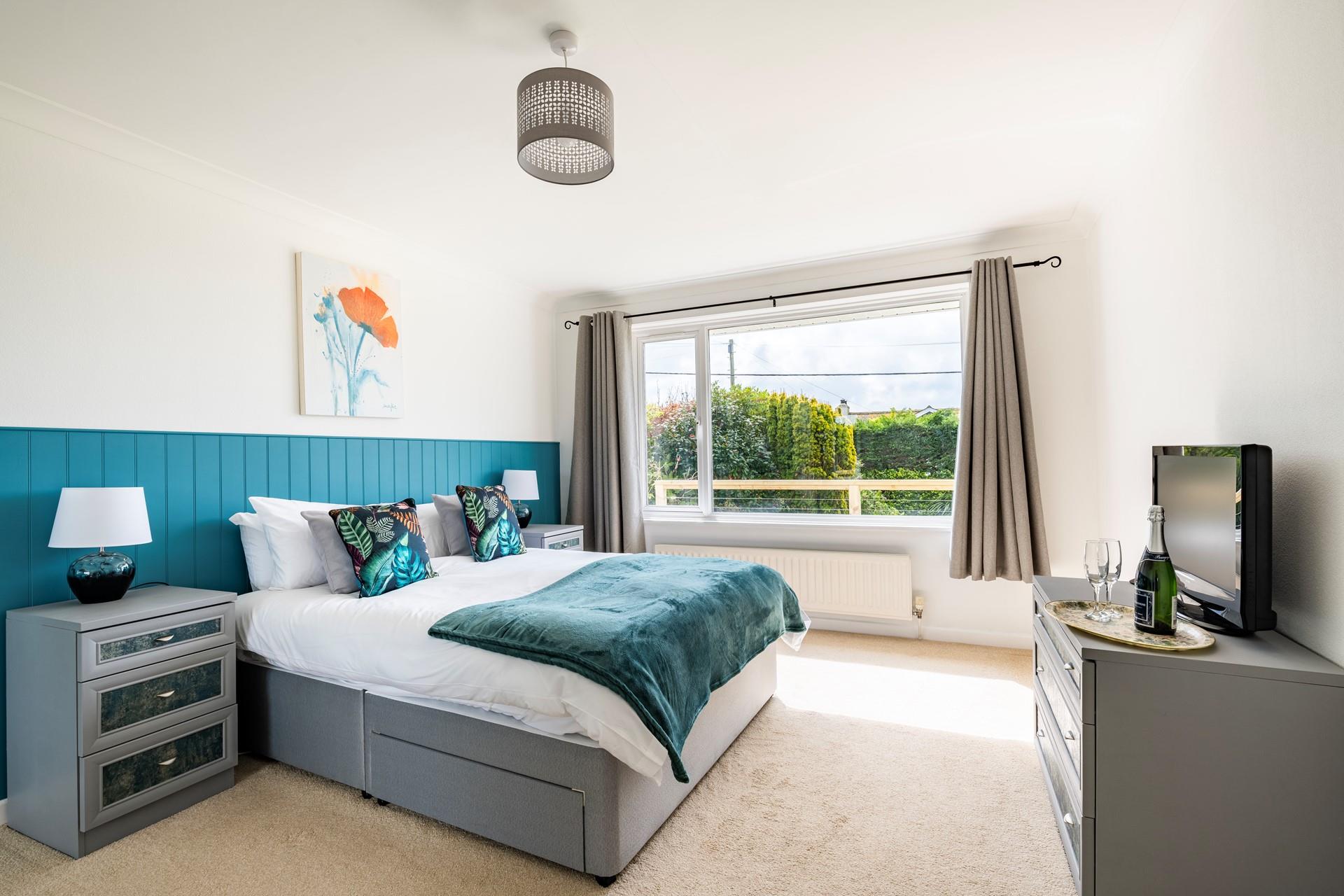Bedroom 1 is decorated with ocean blue colours reflecting the close proximity to the sea.