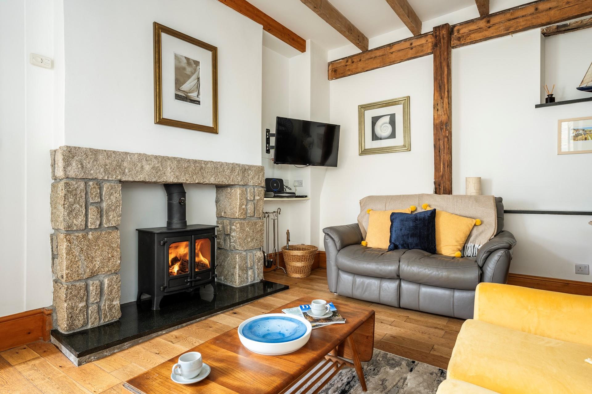The cosy sitting room features a woodburner and exposed beams.