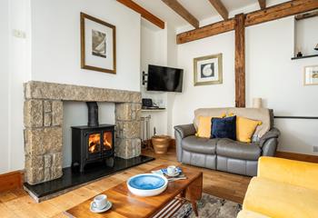 The cosy sitting room features a woodburner and exposed beams.