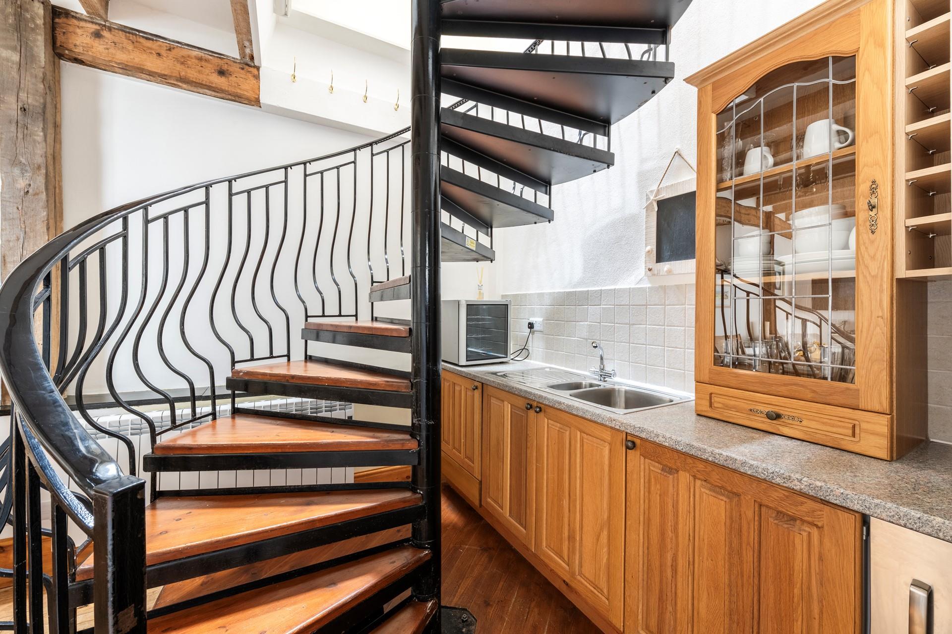 Climb the spiral staircase to the kitchen and bedrooms.
