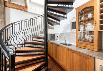 Climb the spiral staircase to the kitchen and bedrooms.