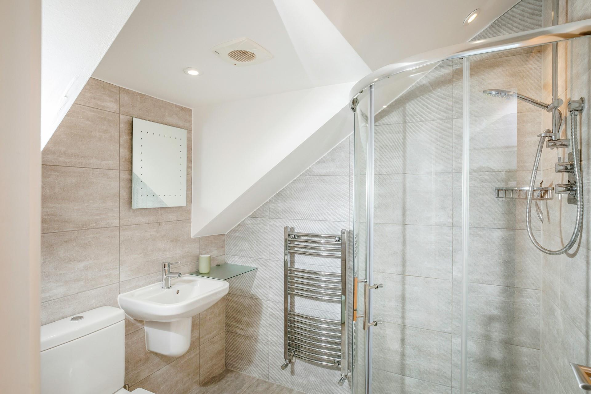 The ensuite shower room is stylish and modern with added luxuries such as the light-up mirror and heated towel rail.