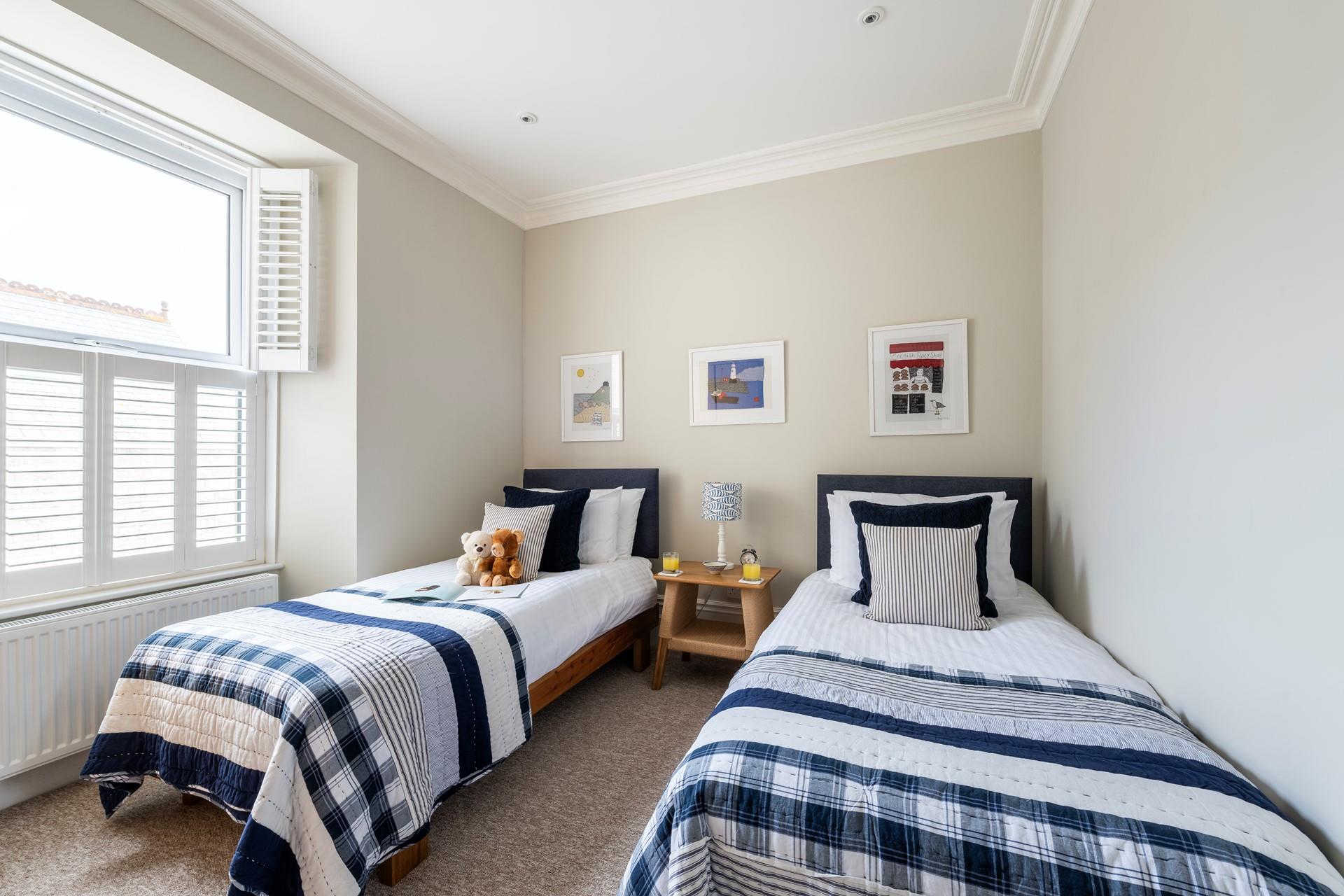 The twin bedroom features more Cornish artwork and nods to the ocean-side location.