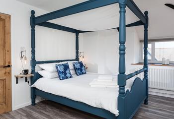 Climb into the soft sheets of the luxurious four-poster bed.