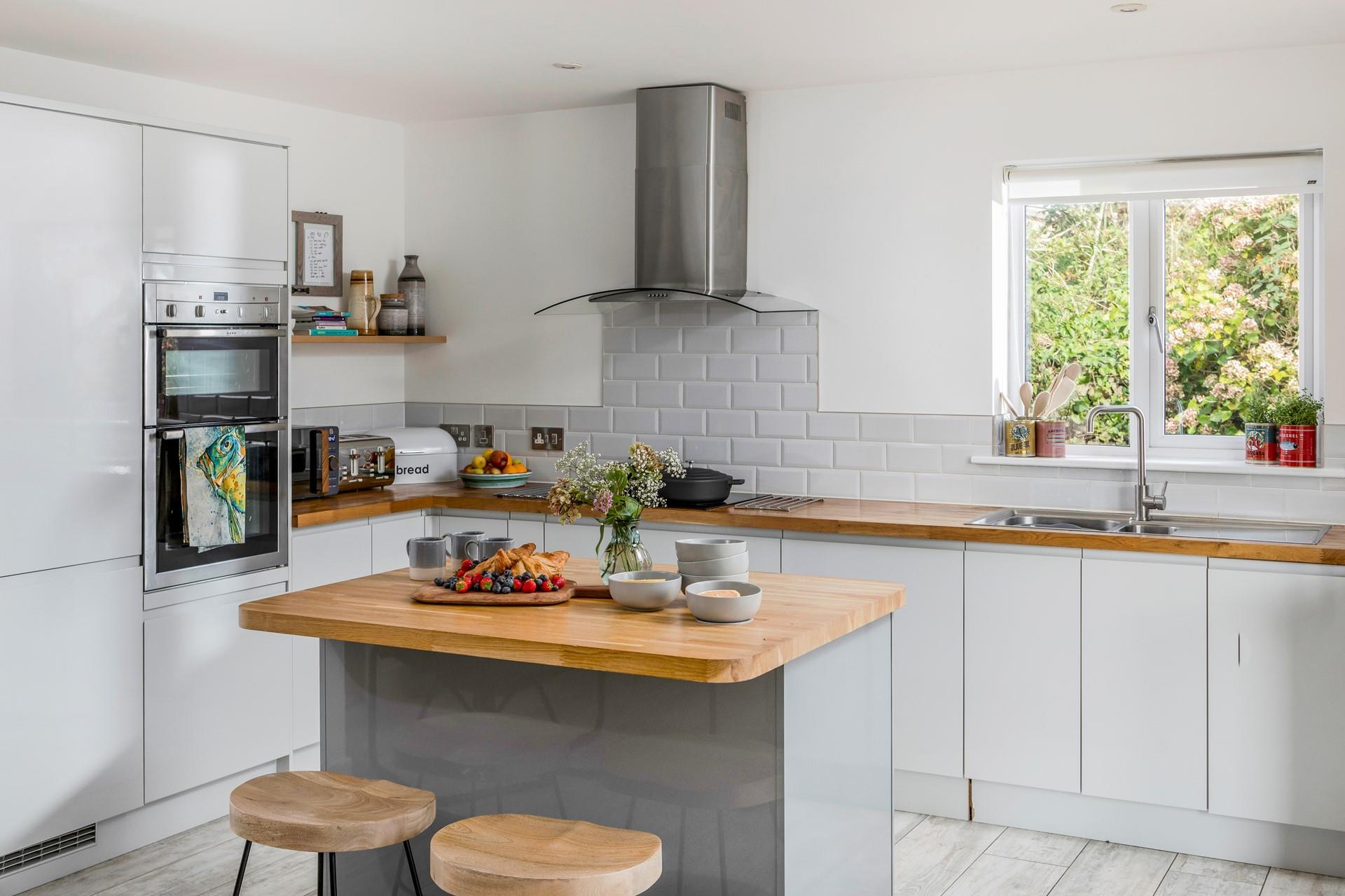 The kitchen is modern and spacious for preparing and cooking meals.