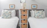 Coastal decor adorns the twin bedroom, a nod to the seaside location. - Thumbnail Image