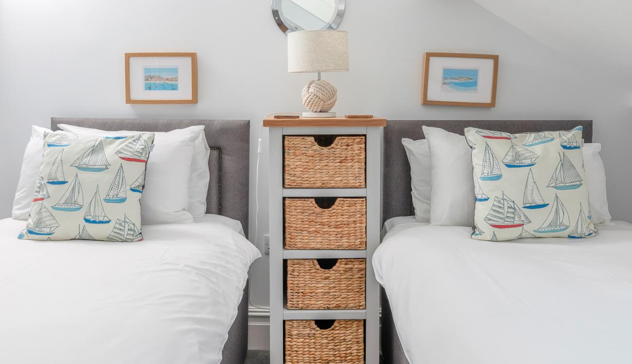 Coastal decor adorns the twin bedroom, a nod to the seaside location.