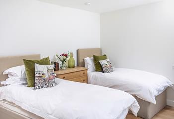 Decorated with forest green cushions, the twin room is a cosy base to relax.