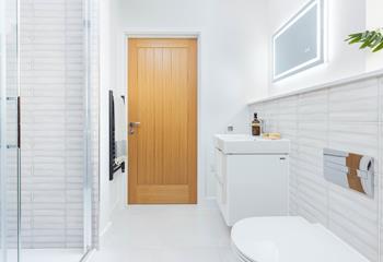 The stylish bathroom has luxury features such as a light-up mirror and heated towel rail.