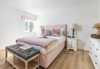 We love the pastel pink colour scheme in the spacious bedroom.