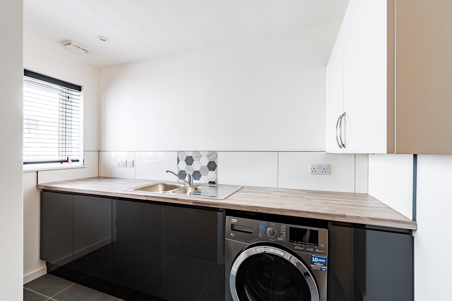 The utility room has a washer, dryer and sink.
