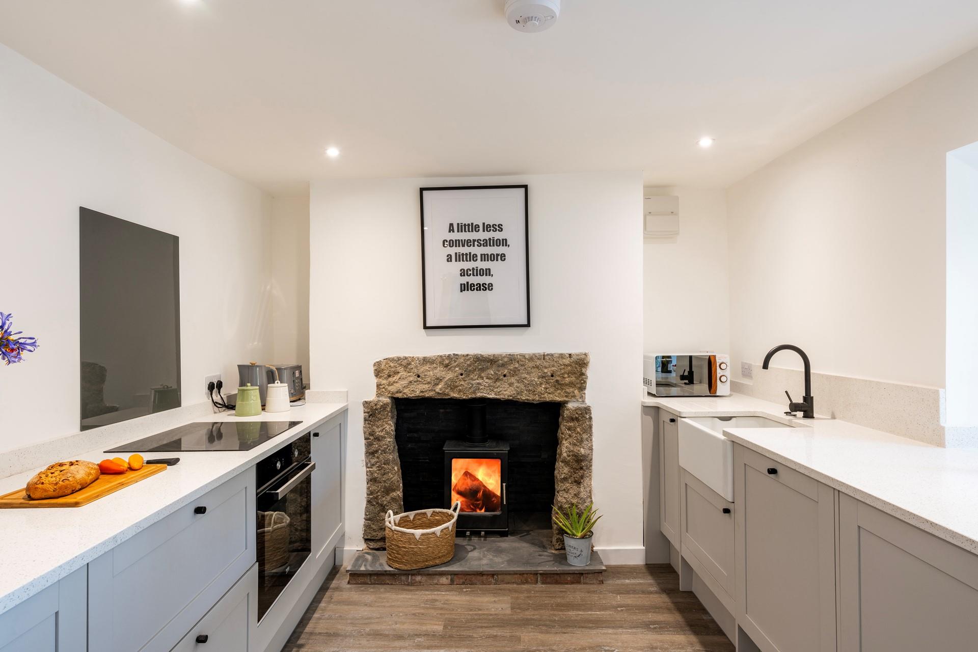 The modern kitchen is well-equipped for cooking hearty meals, with the woodburner roaring in the background, so cosy!