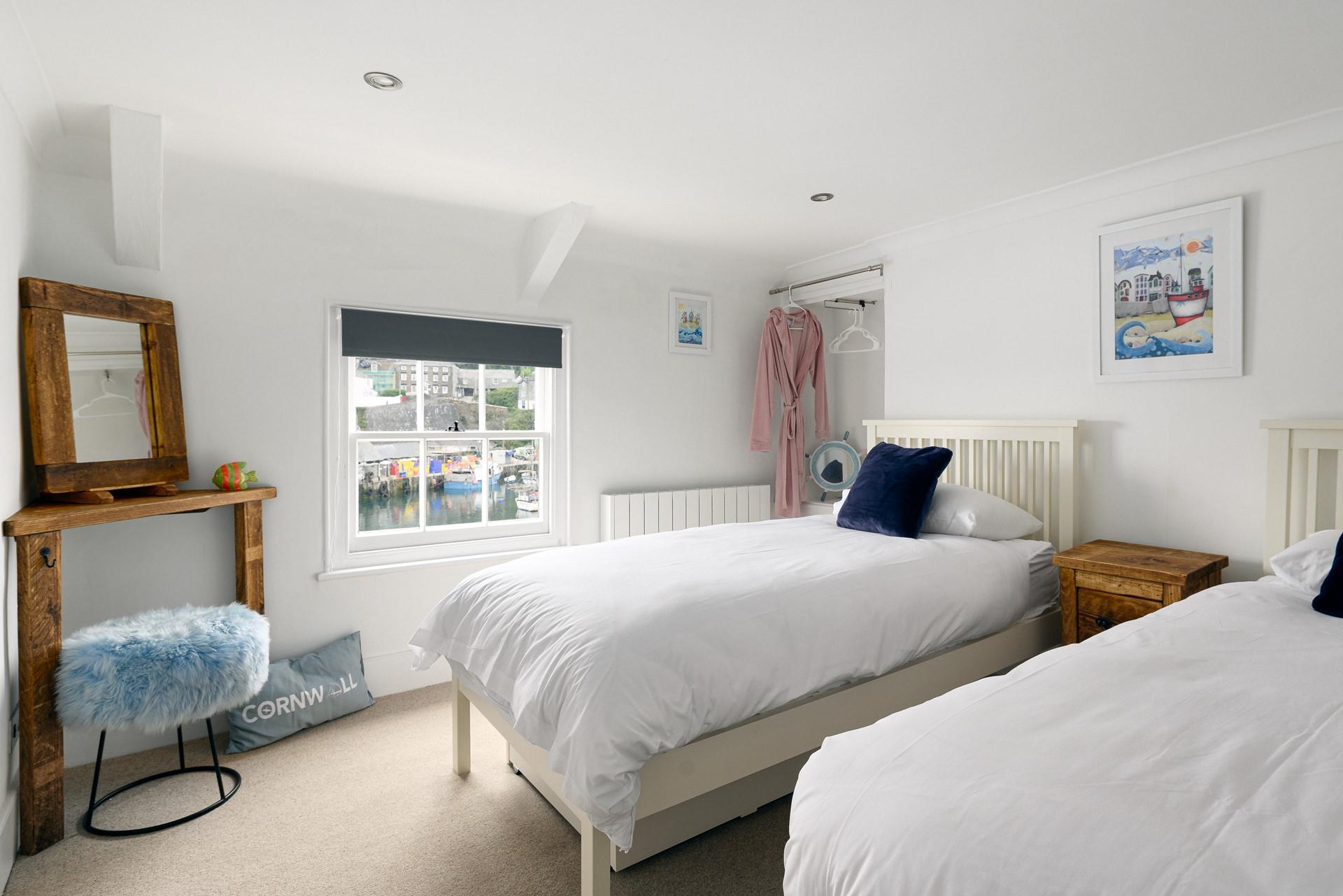 Bedroom 2 is a stylish twin for adults or children with idyllic harbour views.