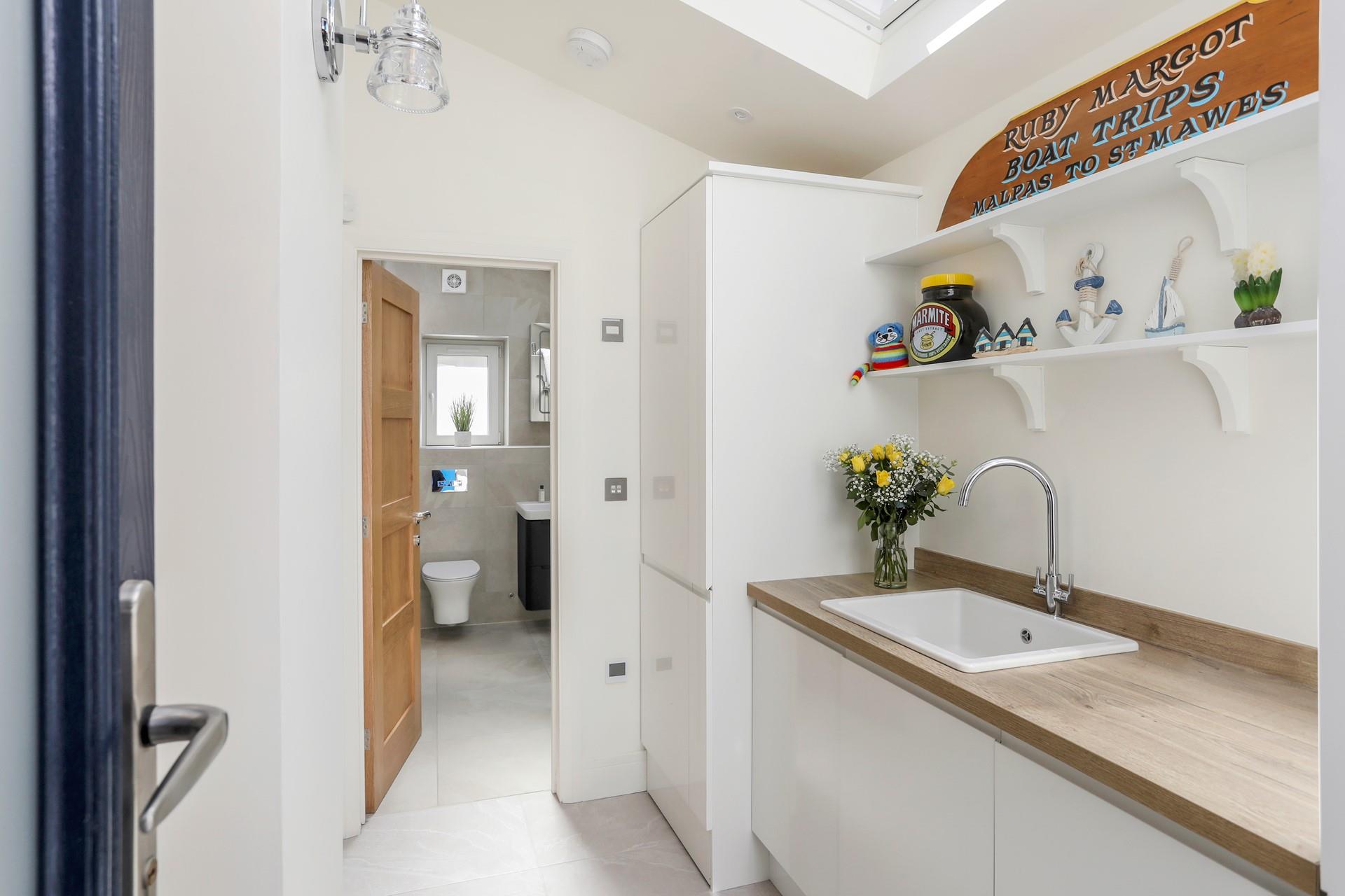 The utility room offers additional space and a washing machine and tumble dryer.