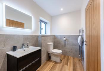 The en suite is modern and sleek with features such as the light-up mirror and heated towel rail.