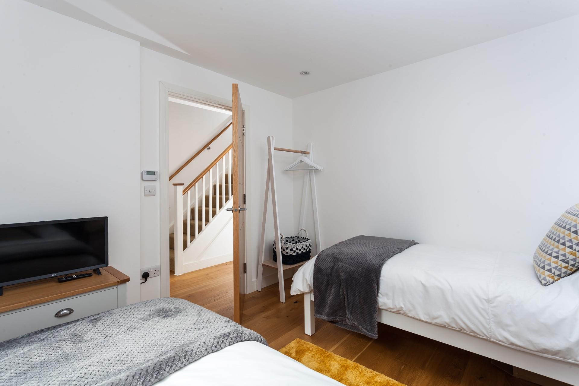 Bedroom 1 has comfortable twin beds and an open clothes hanging rail.