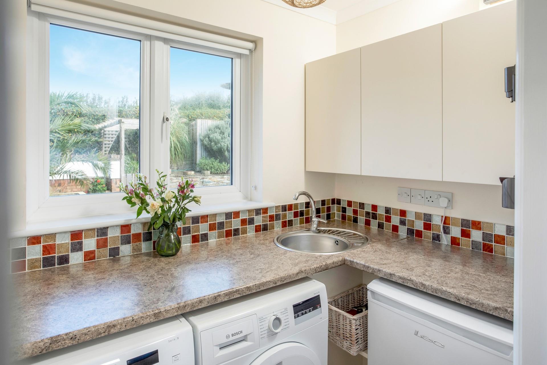 The utility room has a washing machine and tumble dryer.
