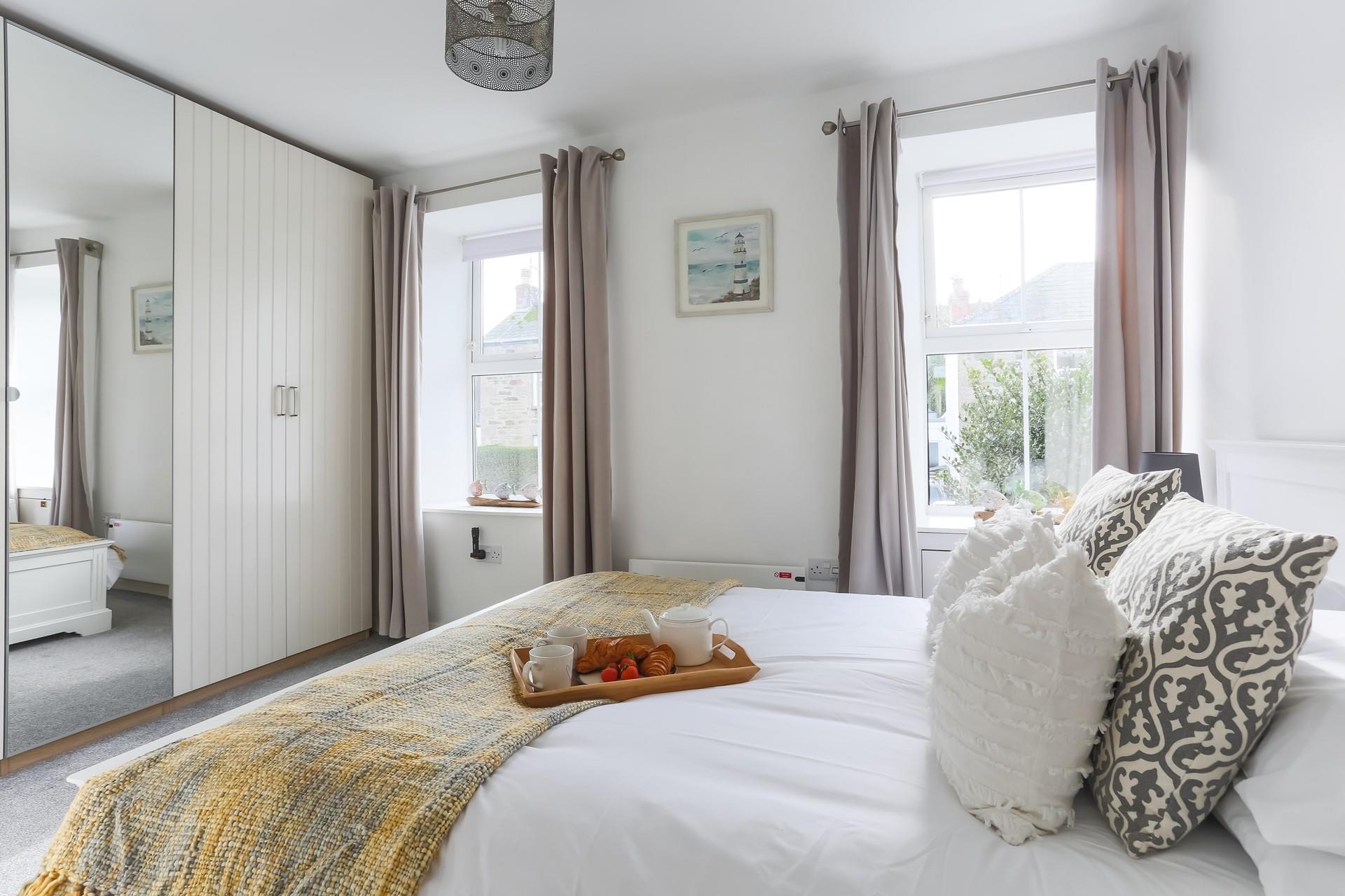 The bedroom has plenty of wardrobe space and is decorated with calming neutral tones.