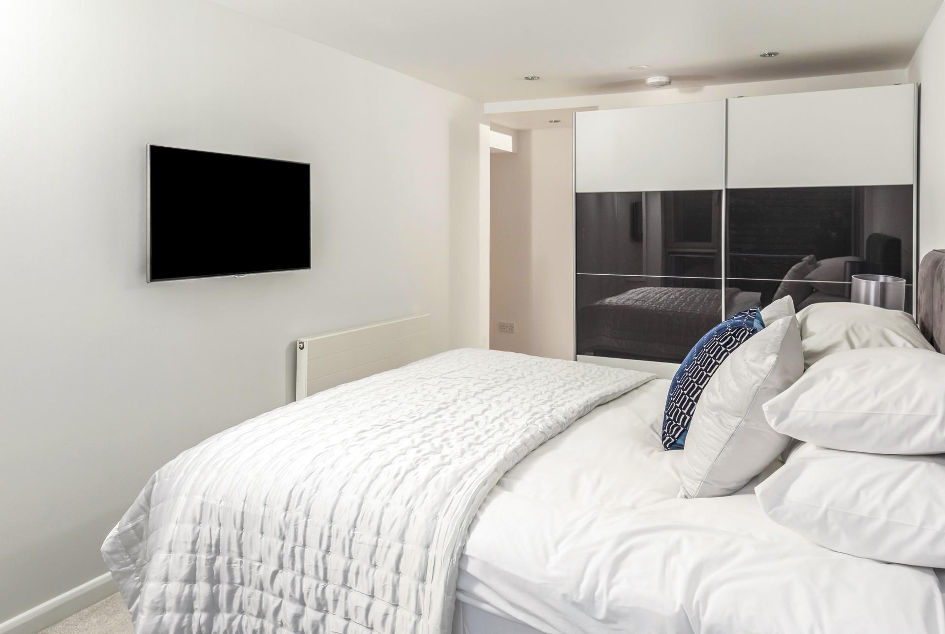 The bedrooms are decorated in neutral tones with a pop of ocean blue.