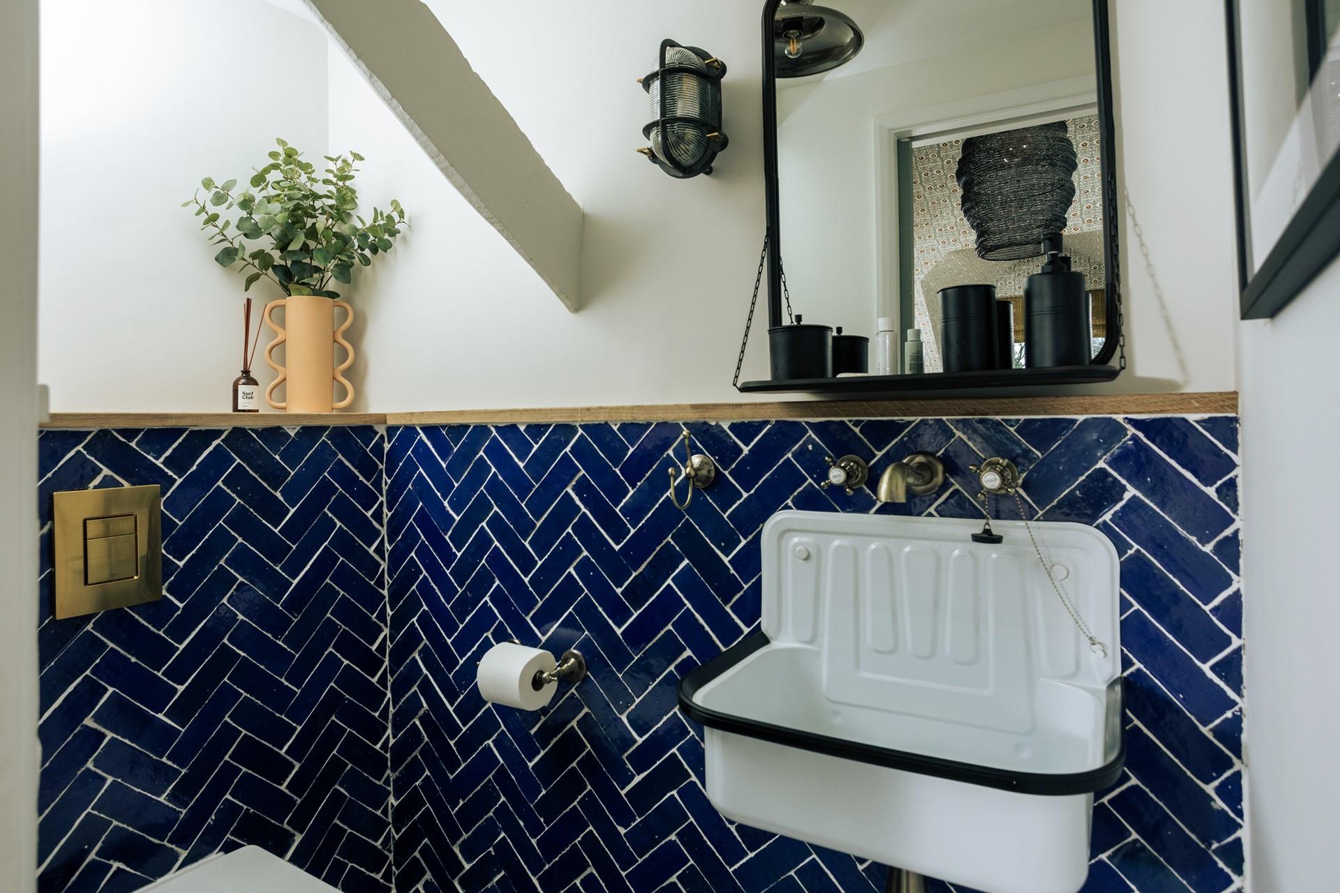 The en-suite boasts a stunning enamel sink and eye-catching tiles.