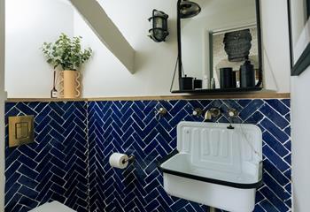 The en-suite boasts a stunning enamel sink and eye-catching tiles.