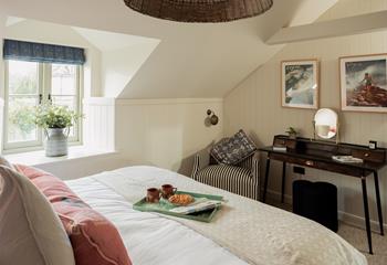 The cosy bedroom mixes cottage style with modern furnishings.