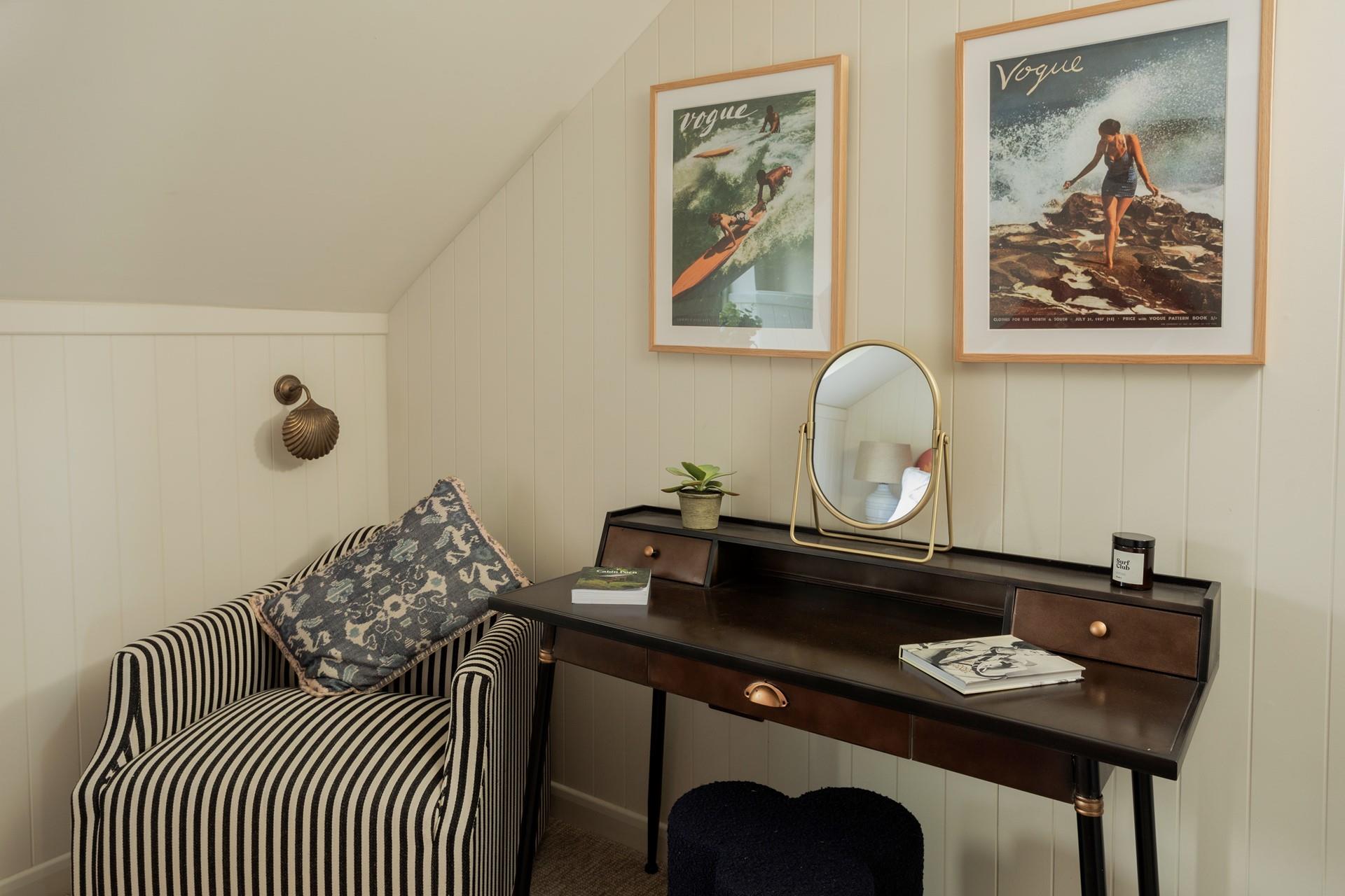 Stylish coastal artwork takes pride of place over the chic dresser.
