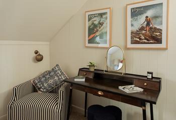 Stylish coastal artwork takes pride of place over the chic dresser.