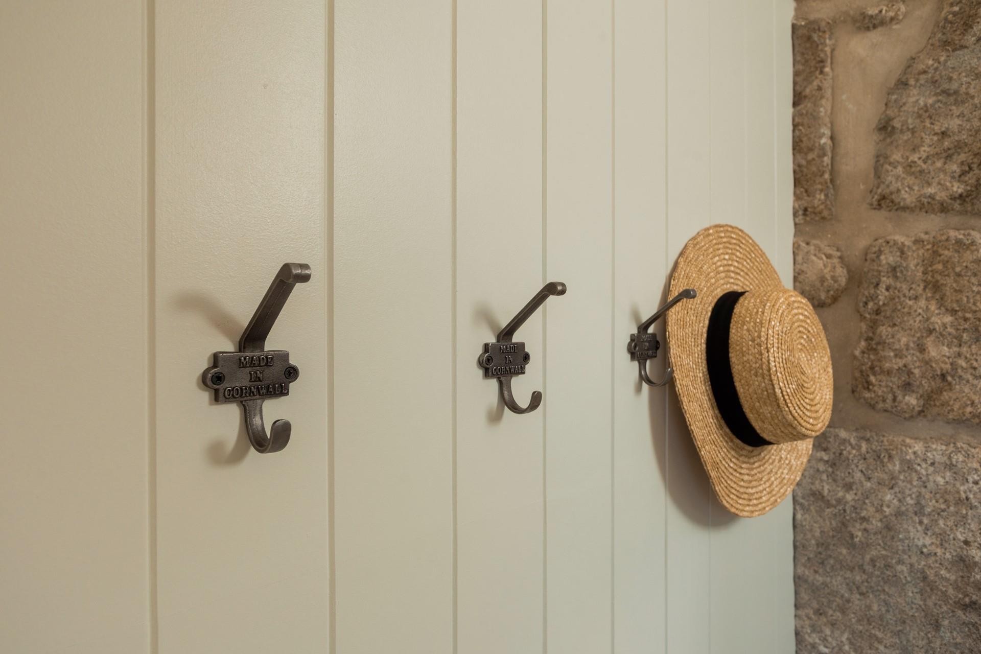 The metal Cornish hooks in the porchway are an elegant touch.