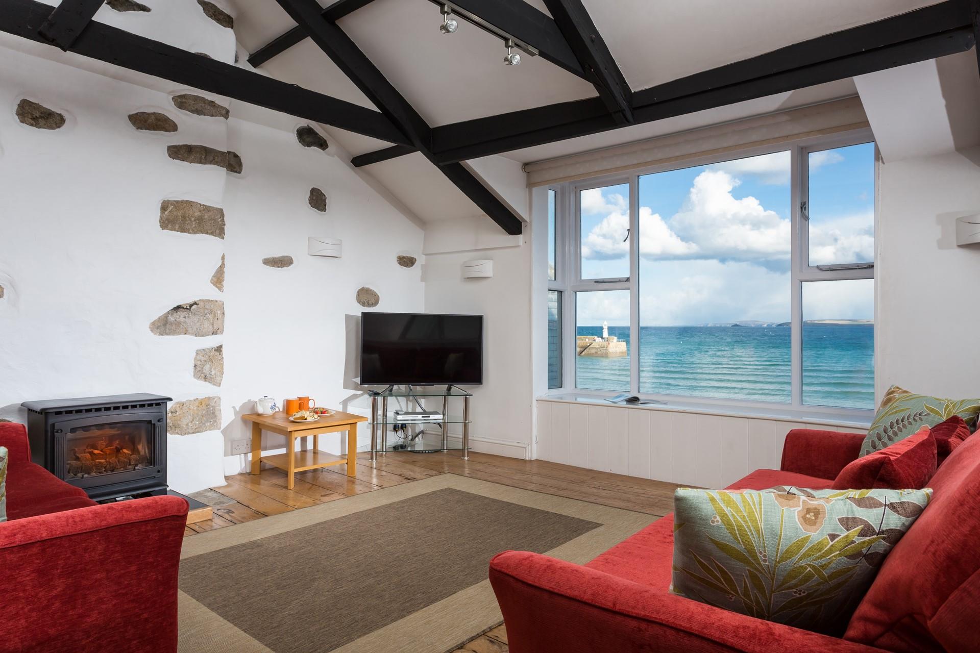 The sitting room offers stunning sea views of St Ives Bay and lighthouse.