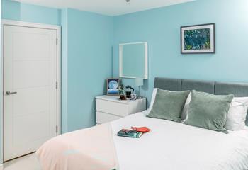 The bedroom is decorated in calming seaside blue tones.