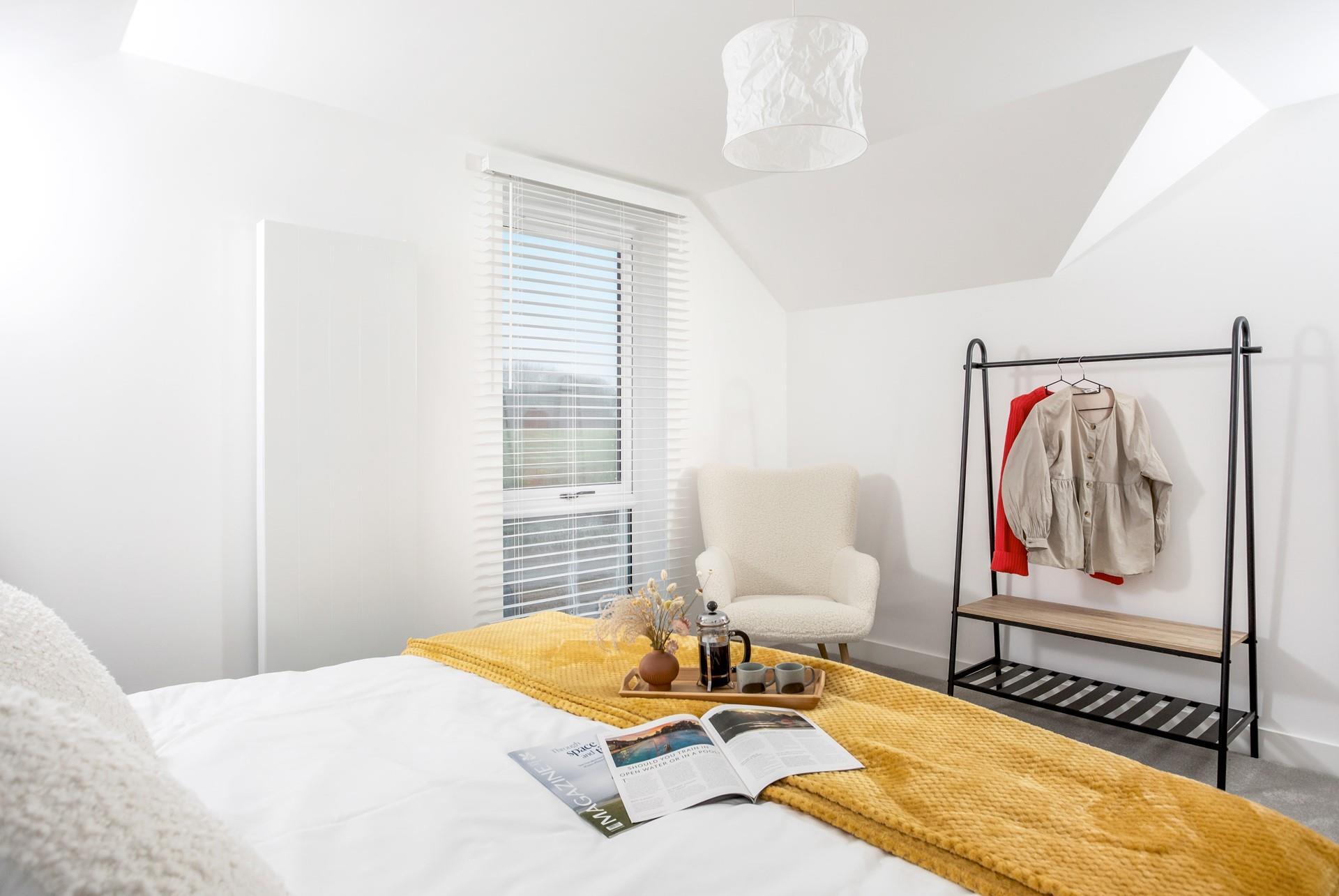 The bedroom has a spacious bed and plenty of hanging space.